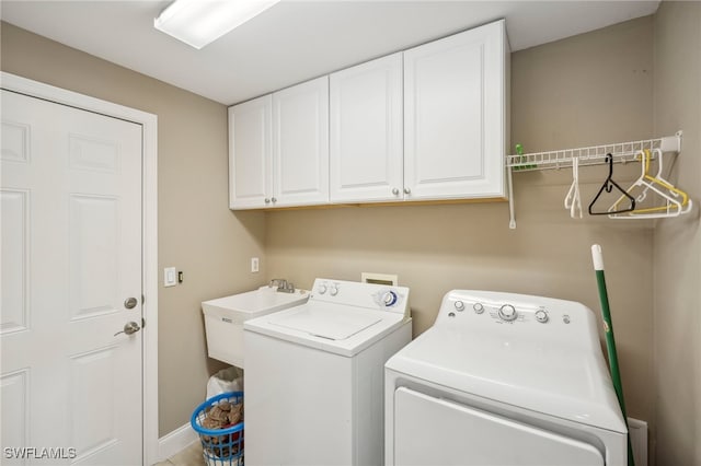 laundry room featuring cabinets, sink, and washing machine and clothes dryer