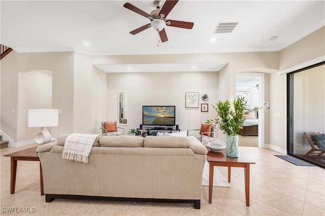 living room featuring crown molding, light tile patterned floors, and ceiling fan