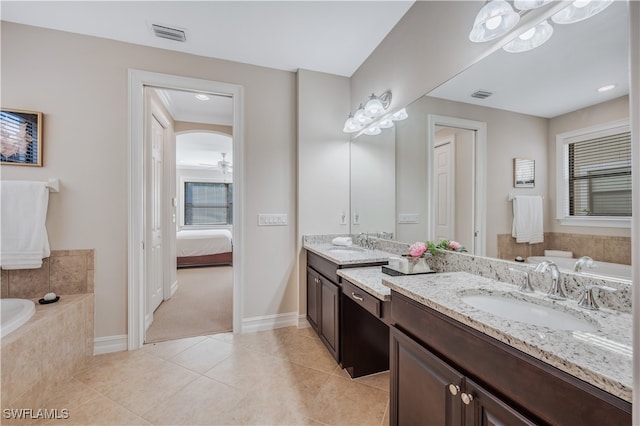 bathroom with vanity, tiled bath, tile patterned flooring, and plenty of natural light