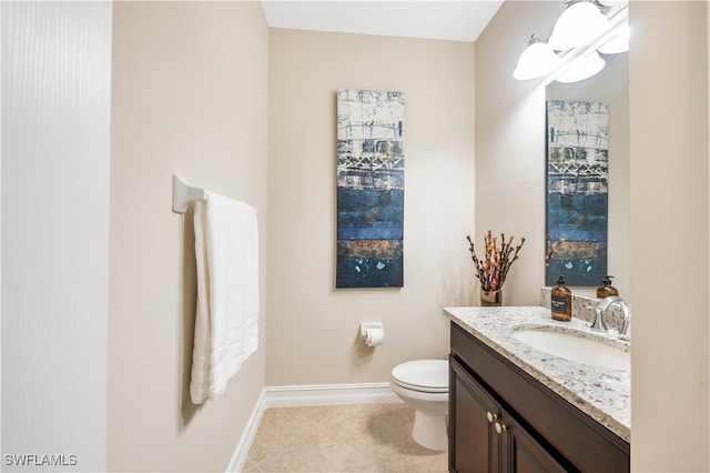 bathroom with toilet, vanity, and tile patterned floors