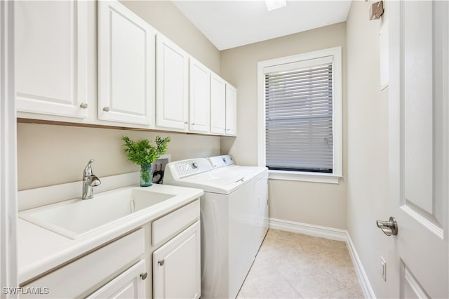 laundry area featuring cabinets, sink, washer and clothes dryer, and light tile patterned floors