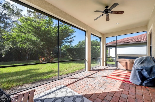 unfurnished sunroom with ceiling fan