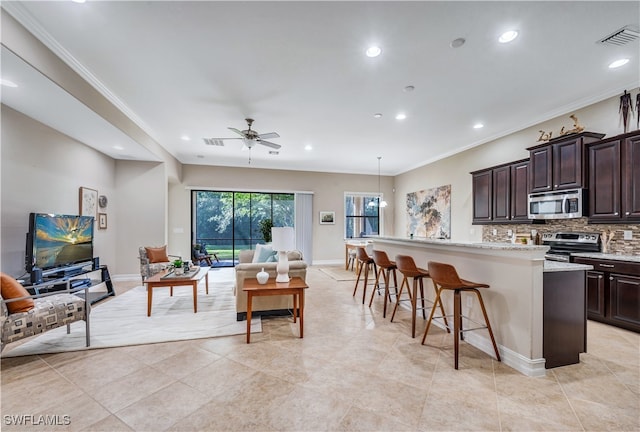 kitchen with decorative backsplash, a center island with sink, a kitchen bar, decorative light fixtures, and stainless steel appliances