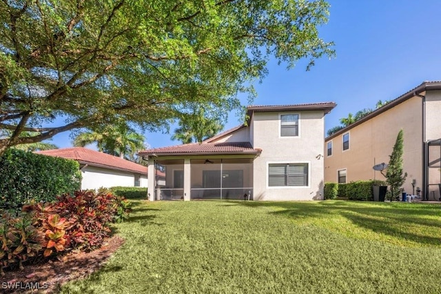 rear view of property with a sunroom and a lawn