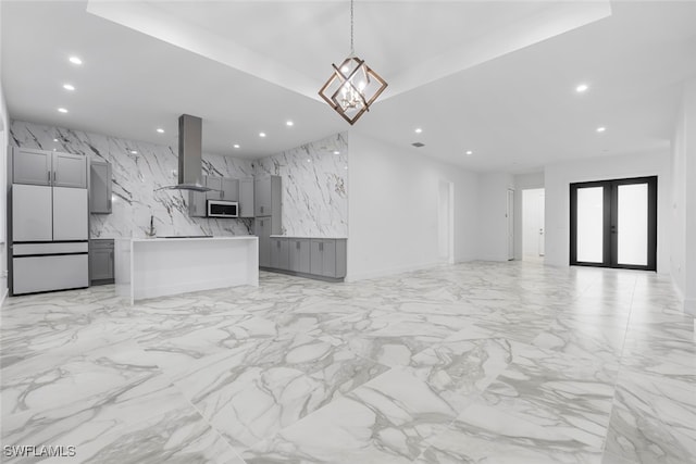 unfurnished living room with french doors and a notable chandelier