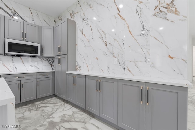 kitchen featuring light stone counters and gray cabinetry