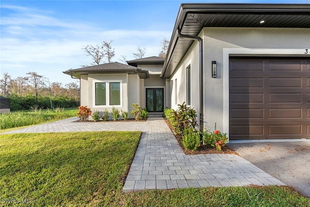 doorway to property featuring a lawn and a garage