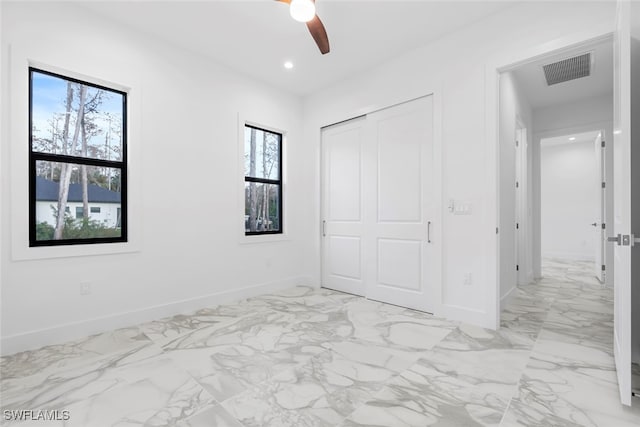 unfurnished bedroom featuring multiple windows, a closet, and ceiling fan