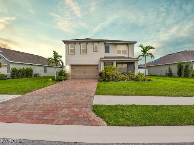 2739 Merida Ln, Cape Coral, FL 33909 - traditional-style home featuring central air condition unit, a garage, a front yard, stucco siding, and decorative driveway