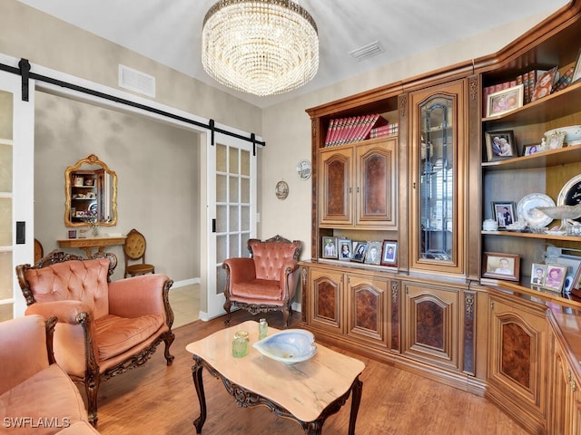 2739 Merida Ln, Cape Coral, FL 33909 - sitting room featuring a barn door, light wood-type flooring, visible vents, and a notable chandelier