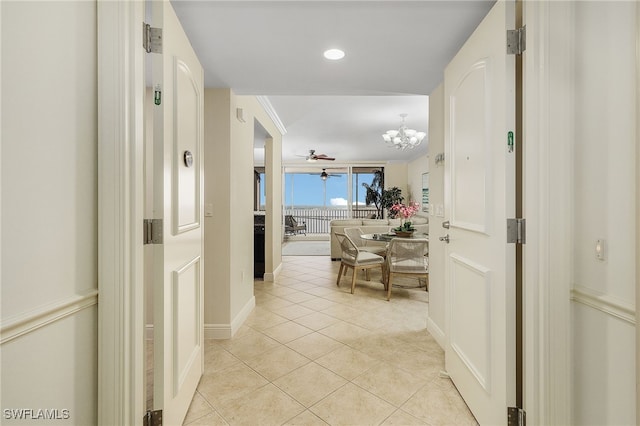 2090 W First St Unit 1609, Fort Myers, FL 33901 - corridor featuring light tile patterned flooring, baseboards, and a notable chandelier