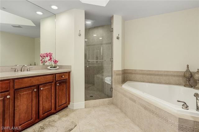 bathroom with vanity, a skylight, tile patterned floors, and separate shower and tub