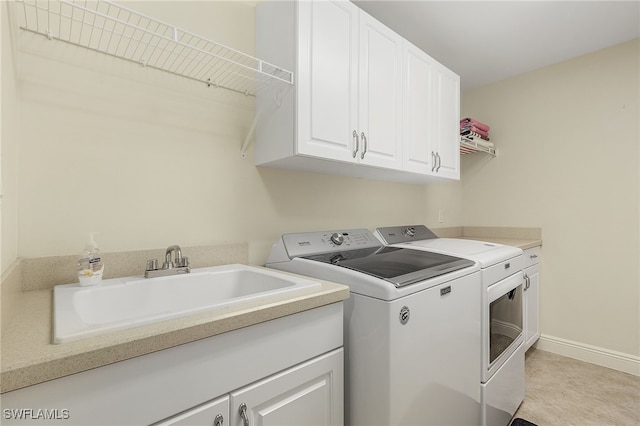 laundry room featuring sink, cabinets, and separate washer and dryer