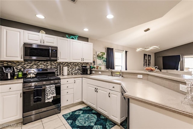 kitchen featuring white cabinets, appliances with stainless steel finishes, light tile patterned floors, and sink