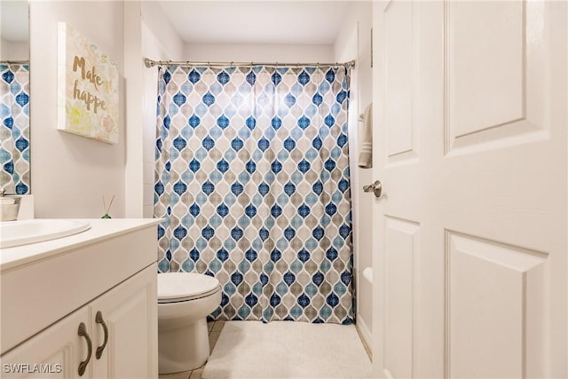 bathroom with tile patterned flooring, vanity, and toilet