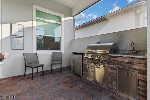 view of patio / terrace featuring sink, an outdoor kitchen, and a grill