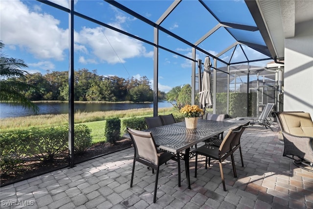 view of patio featuring a water view and glass enclosure