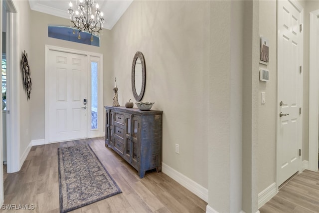 entryway featuring light hardwood / wood-style floors, ornamental molding, and a wealth of natural light