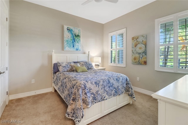 bedroom featuring multiple windows, light colored carpet, and ceiling fan