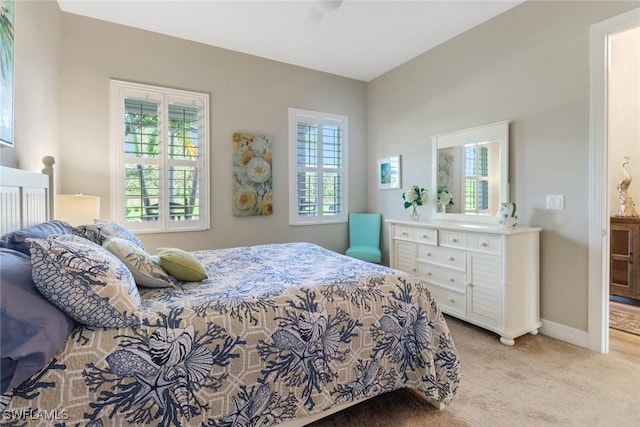 carpeted bedroom featuring ceiling fan and multiple windows