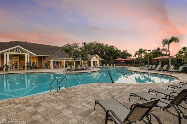 pool at dusk with a patio area