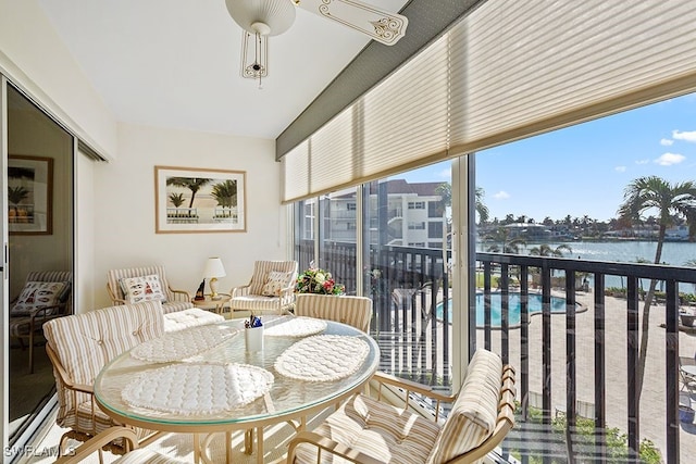 sunroom featuring a water view