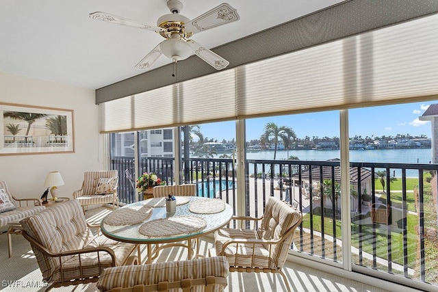 sunroom / solarium featuring a water view, ceiling fan, and plenty of natural light