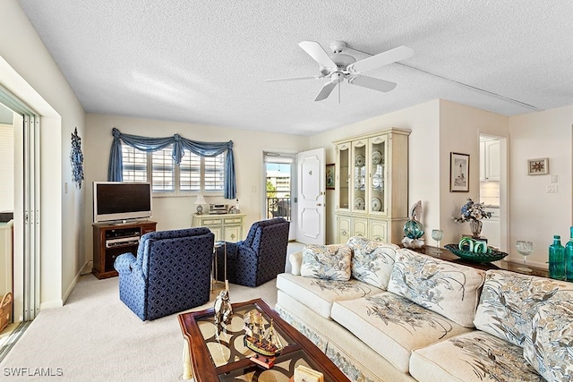 living room featuring a textured ceiling, light colored carpet, and ceiling fan