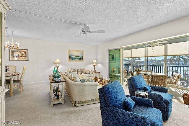 carpeted living room with a water view, a textured ceiling, and ceiling fan with notable chandelier