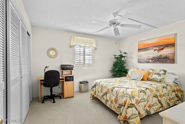 carpeted bedroom featuring a closet, a textured ceiling, and ceiling fan