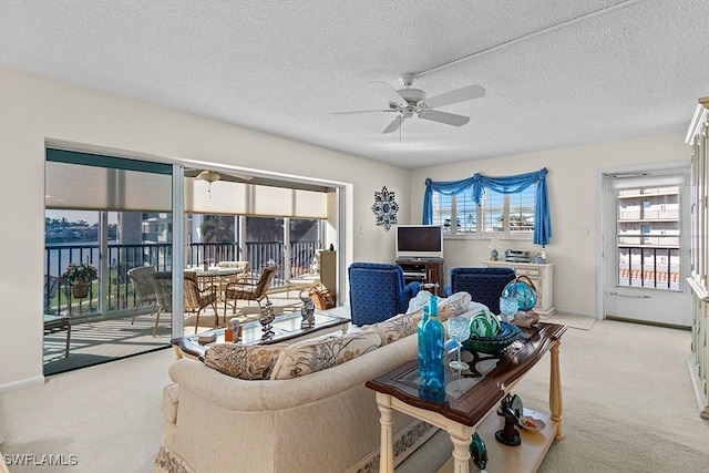 living room featuring a textured ceiling, light colored carpet, and ceiling fan