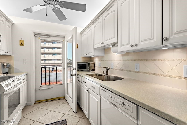 kitchen with white appliances, backsplash, sink, and white cabinets