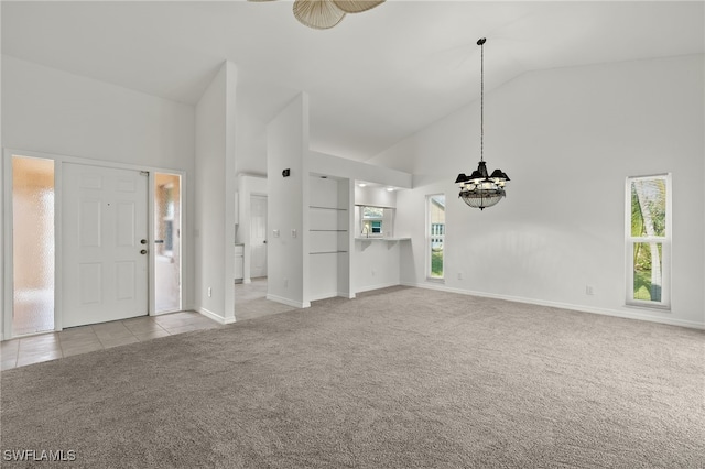 interior space with light colored carpet, a chandelier, and high vaulted ceiling