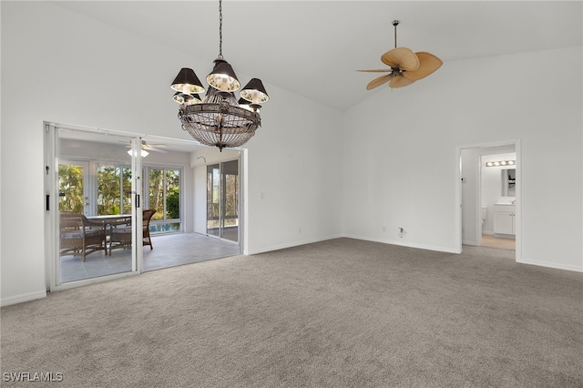 unfurnished living room with ceiling fan with notable chandelier, carpet flooring, and high vaulted ceiling