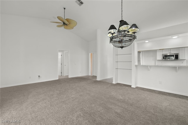 unfurnished living room featuring high vaulted ceiling, carpet, and ceiling fan with notable chandelier