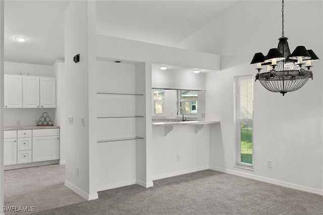 unfurnished dining area featuring light carpet, a chandelier, and sink