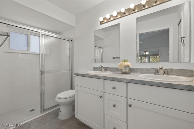 bathroom featuring vanity, tile patterned flooring, toilet, and an enclosed shower