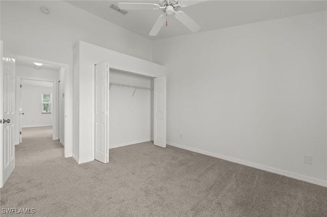 unfurnished bedroom with light colored carpet, a closet, and ceiling fan