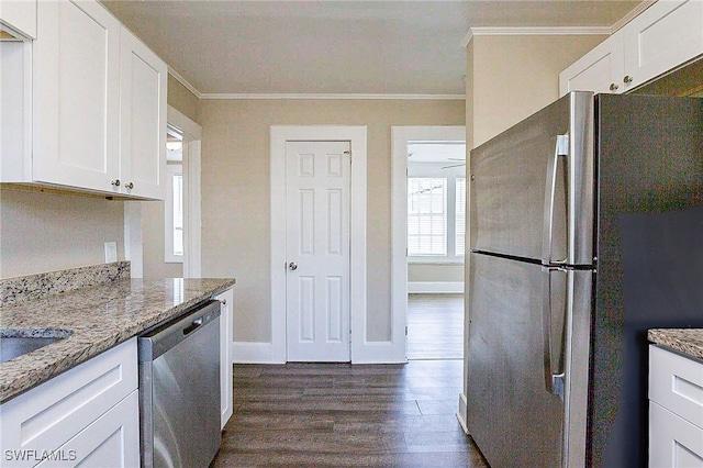 kitchen with appliances with stainless steel finishes, light stone counters, and white cabinets