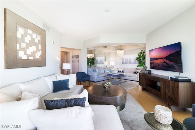 living room featuring an inviting chandelier and light hardwood / wood-style flooring