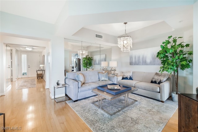 living room with an inviting chandelier and light wood-type flooring