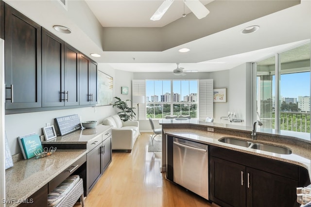 kitchen with light stone countertops, sink, dishwasher, dark brown cabinets, and light hardwood / wood-style floors