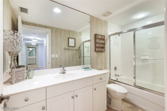 full bathroom with vanity, shower / bath combination with glass door, toilet, and tile patterned floors