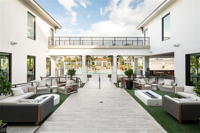 exterior space featuring a balcony, a pool, and outdoor lounge area