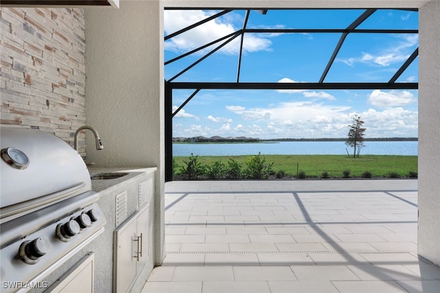 view of patio / terrace featuring grilling area, sink, a water view, and glass enclosure