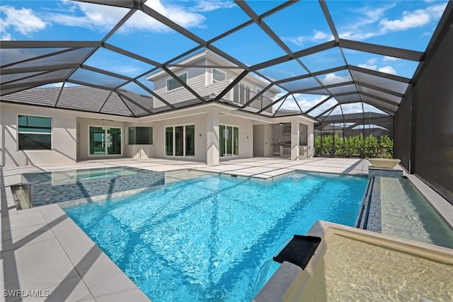 view of pool featuring glass enclosure, a patio, and a pool with connected hot tub