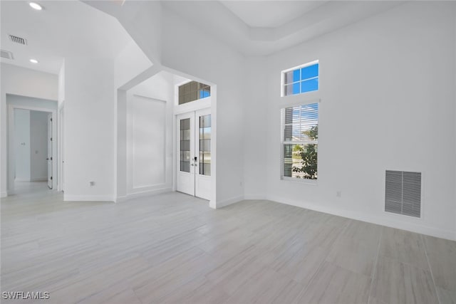 spare room with french doors, visible vents, and baseboards