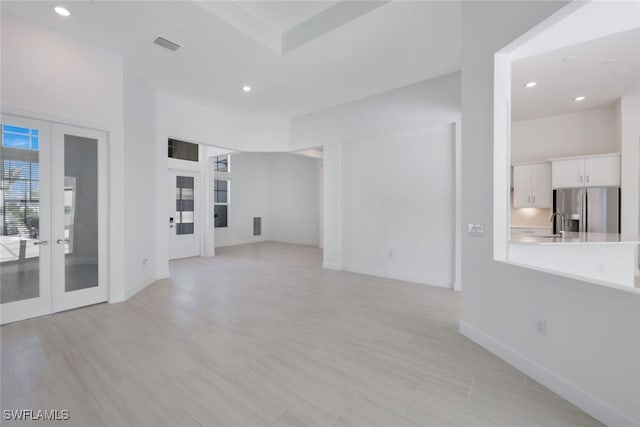 unfurnished living room with recessed lighting, visible vents, baseboards, and french doors