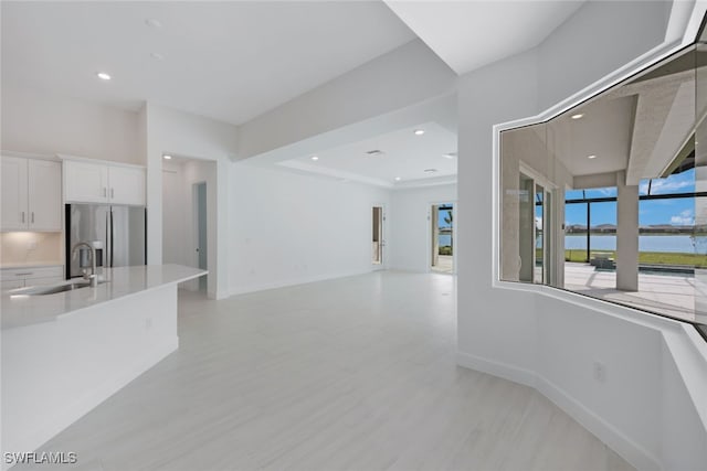 living area with a water view, baseboards, and recessed lighting