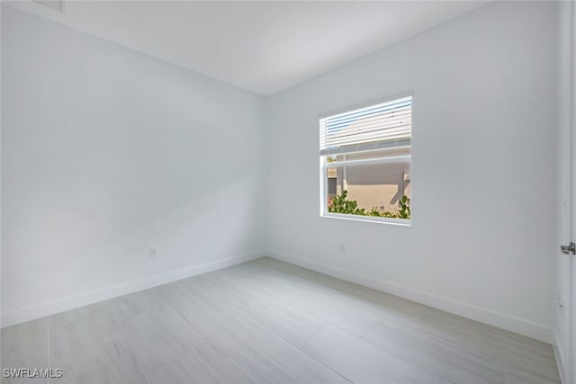 unfurnished room with baseboards